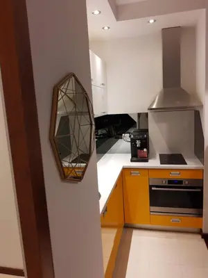 a kitchen with an orange and white counter top at JM Apartment Old Town Krakow in Kraków