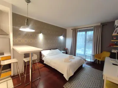 a bedroom with a bed and a table and a window at JM Apartment Old Town Krakow in Kraków