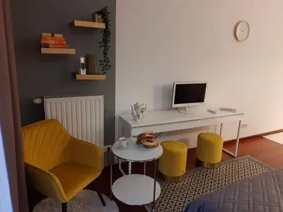 a room with a desk with a computer and yellow chairs at JM Apartment Old Town Krakow in Kraków