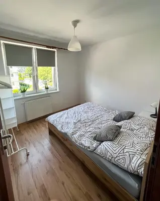 a bedroom with a bed in a room at Uroczy Apartament Pod Skarpą in Wadowice