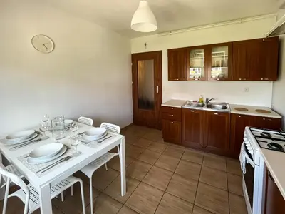 a kitchen with a white table with plates on it at Uroczy Apartament Pod Skarpą in Wadowice
