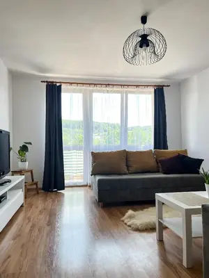 a living room with a couch and a large window at Uroczy Apartament Pod Skarpą in Wadowice