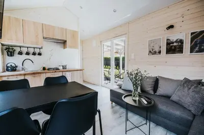 a living room with a couch and a table at Domki Energylandia Zator Przybradz in Przybradz
