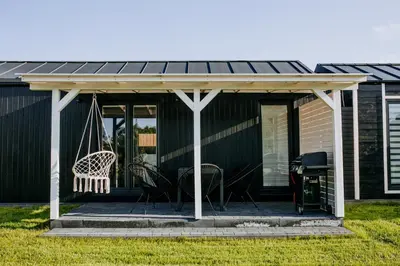 a screened in porch with a roof on a house at Domki Energylandia Zator Przybradz in Przybradz