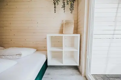 a small room with a bed and a shelf at Domki Energylandia Zator Przybradz in Przybradz