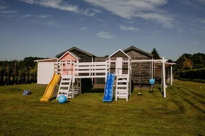 a house with a playground with a slide at Domki Energylandia Zator Przybradz in Przybradz