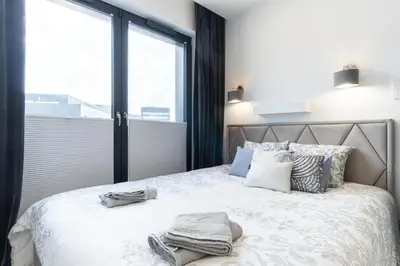 a bedroom with a bed with a large window at Lovely flat Fabryczna Street AC free parking in Kraków