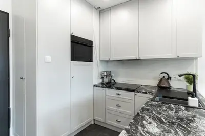 a kitchen with white cabinets and a counter top at Lovely flat Fabryczna Street AC free parking in Kraków