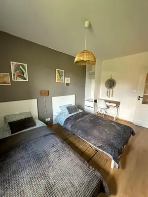 a bedroom with two beds and a table at Dekoratoria Apartments in Kraków