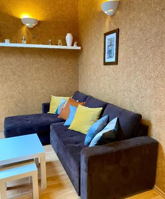 a living room with a black couch with colorful pillows at Dekoratoria Apartments in Kraków