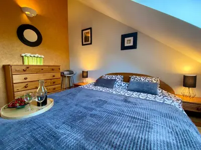 a bedroom with a large blue bed with a table at Dekoratoria Apartments in Kraków