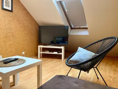 a living room with a chair and a table at Dekoratoria Apartments in Kraków