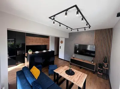 a living room with a blue couch and a table at Apartament Helsinki in Zator