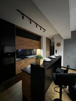 a kitchen with a black island in a room at Apartament Helsinki in Zator