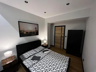 a bedroom with a bed and a picture on the wall at Apartament Helsinki in Zator