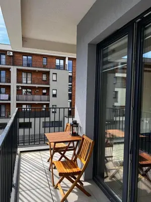 a balcony with a table and chairs on a building at Apartament Helsinki in Zator