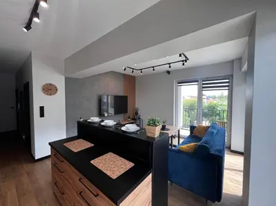 a living room with a blue couch and a table at Apartament Helsinki in Zator