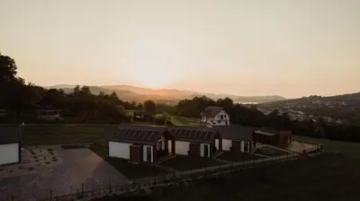 an aerial view of a house with mountains in the background at Tulichatki domki całoroczne in Tarnawa Dolna