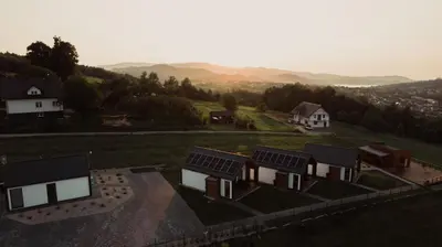 a group of houses with solar panels on a hill at Tulichatki domki całoroczne in Tarnawa Dolna