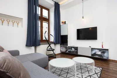 a living room with a couch and two tables at City of the Kings - Old Depot Apartment in Kraków