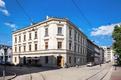 a white building on the corner of a street at City of the Kings - Old Depot Apartment in Kraków