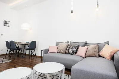 a living room with a gray couch and tables at City of the Kings - Old Depot Apartment in Kraków