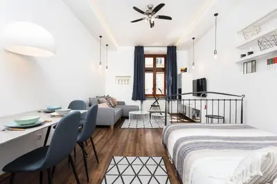 a bedroom with a bed and a living room at City of the Kings - Old Depot Apartment in Kraków