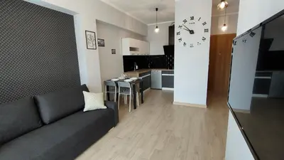 a living room with a couch and a clock on a wall at Apartament KoraZone 2 ZATOR in Zator