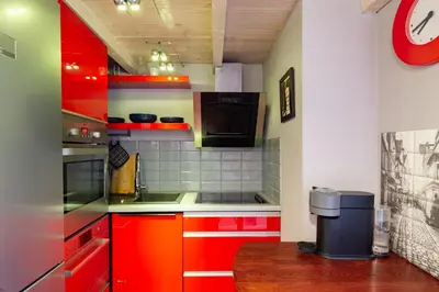 a kitchen with red cabinets and a counter top at Lilly apartment main train station old town by The Heritage House Main Square Cracow in Kraków