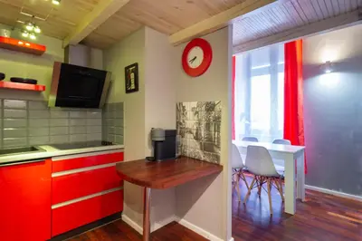 a kitchen with red cabinets and a table with chairs at Lilly apartment main train station old town by The Heritage House Main Square Cracow in Kraków