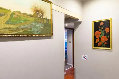 a painting hanging on a wall next to a hallway at Lilly apartment main train station old town by The Heritage House Main Square Cracow in Kraków