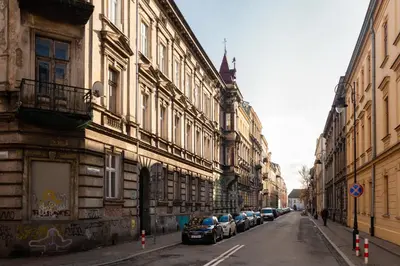 a row of cars parked on a street next to buildings at Lilly apartment main train station old town by The Heritage House Main Square Cracow in Kraków