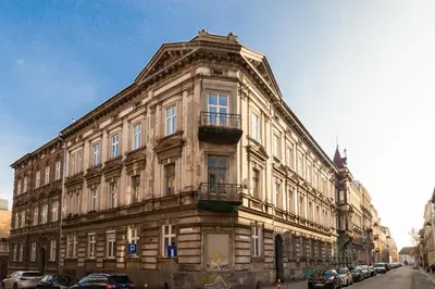 a large stone building with cars parked in front of it at Lilly apartment main train station old town by The Heritage House Main Square Cracow in Kraków