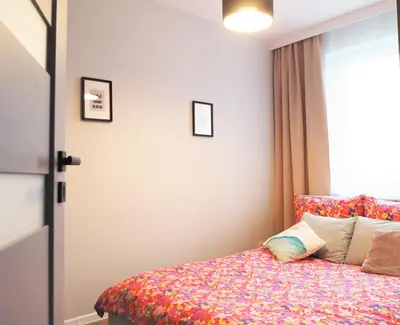 a bedroom with a bed with a floral bedspread at Republiki in Kraków