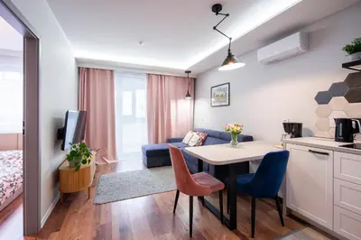 a small apartment with a kitchen and a table and chairs at Republiki in Kraków
