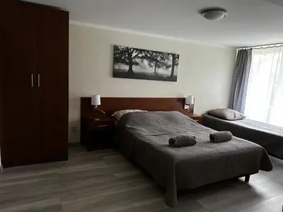 a bedroom with two beds and a large window at Kompleks Apartament-Serwis in Kraków