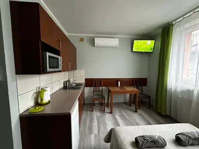 a small kitchen with a sink and a table at Kompleks Apartament-Serwis in Kraków