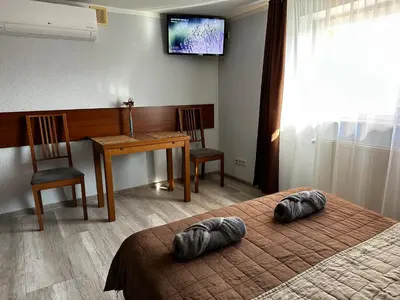a room with two beds and a table and a television at Kompleks Apartament-Serwis in Kraków