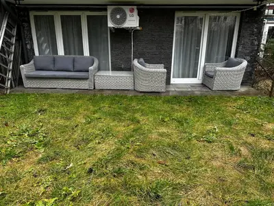 three wicker chairs sitting on the porch of a house at Kompleks Apartament-Serwis in Kraków