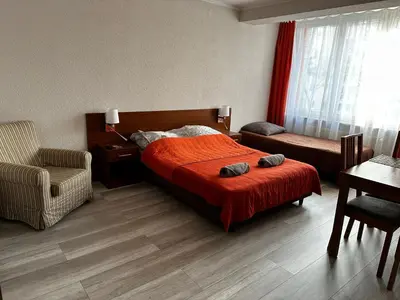 a bedroom with a bed with a red blanket and a chair at Kompleks Apartament-Serwis in Kraków