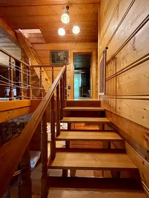 a staircase in a cabin with wooden walls and ceilings at Dom z bali przy szlaku in Kasina Wielka