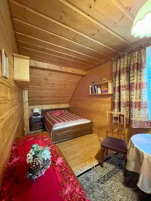 a room with a bed in a wooden room at Dom z bali przy szlaku in Kasina Wielka