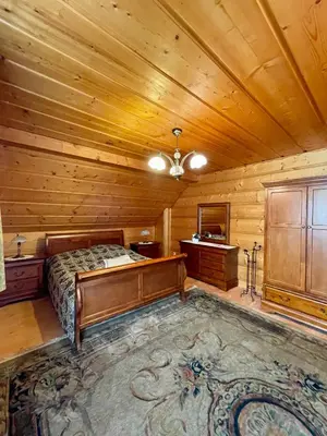 a bedroom with a bed and a wooden ceiling at Dom z bali przy szlaku in Kasina Wielka