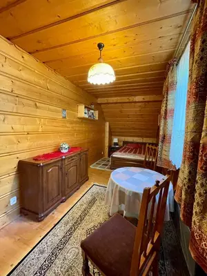 a room with a table and a bed in a cabin at Dom z bali przy szlaku in Kasina Wielka
