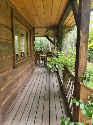 a porch of a cabin with a wooden deck at Dom z bali przy szlaku in Kasina Wielka