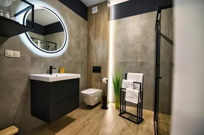 a bathroom with a sink and a mirror at Apartament Proste Chwile 38 by Housine in Zator