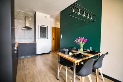 a kitchen and dining room with a table and chairs at Apartament Proste Chwile 38 by Housine in Zator