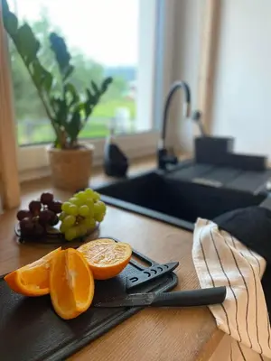 a cutting board with oranges and grapes and a knife at ORAWSKA CHATA domek z balią pod Babią Górą in Zubrzyca Górna