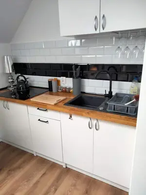 a kitchen with white cabinets and a sink at Urokliwy Zakątek to apartament tylko dla Państwa in Osiek