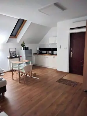 a living room with a table and a kitchen at Urokliwy Zakątek to apartament tylko dla Państwa in Osiek